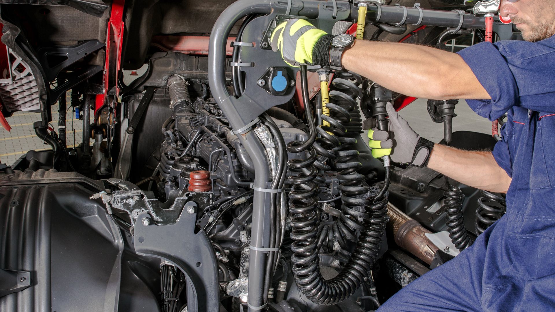 Mechanic repairing complex engine with multiple tubes and suspension springs